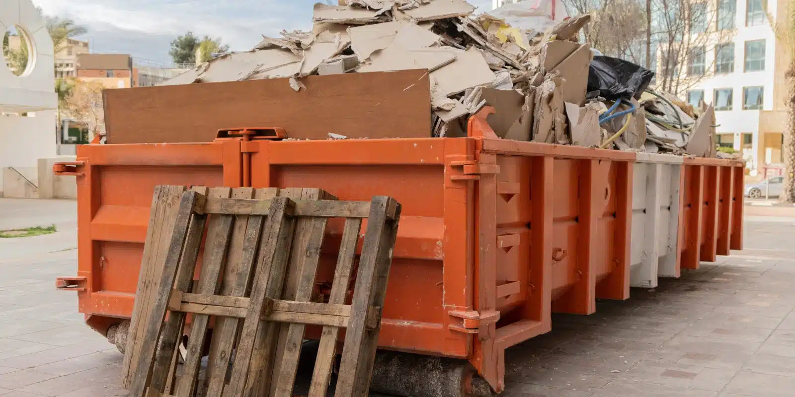 Large orange dumpster with construction debris