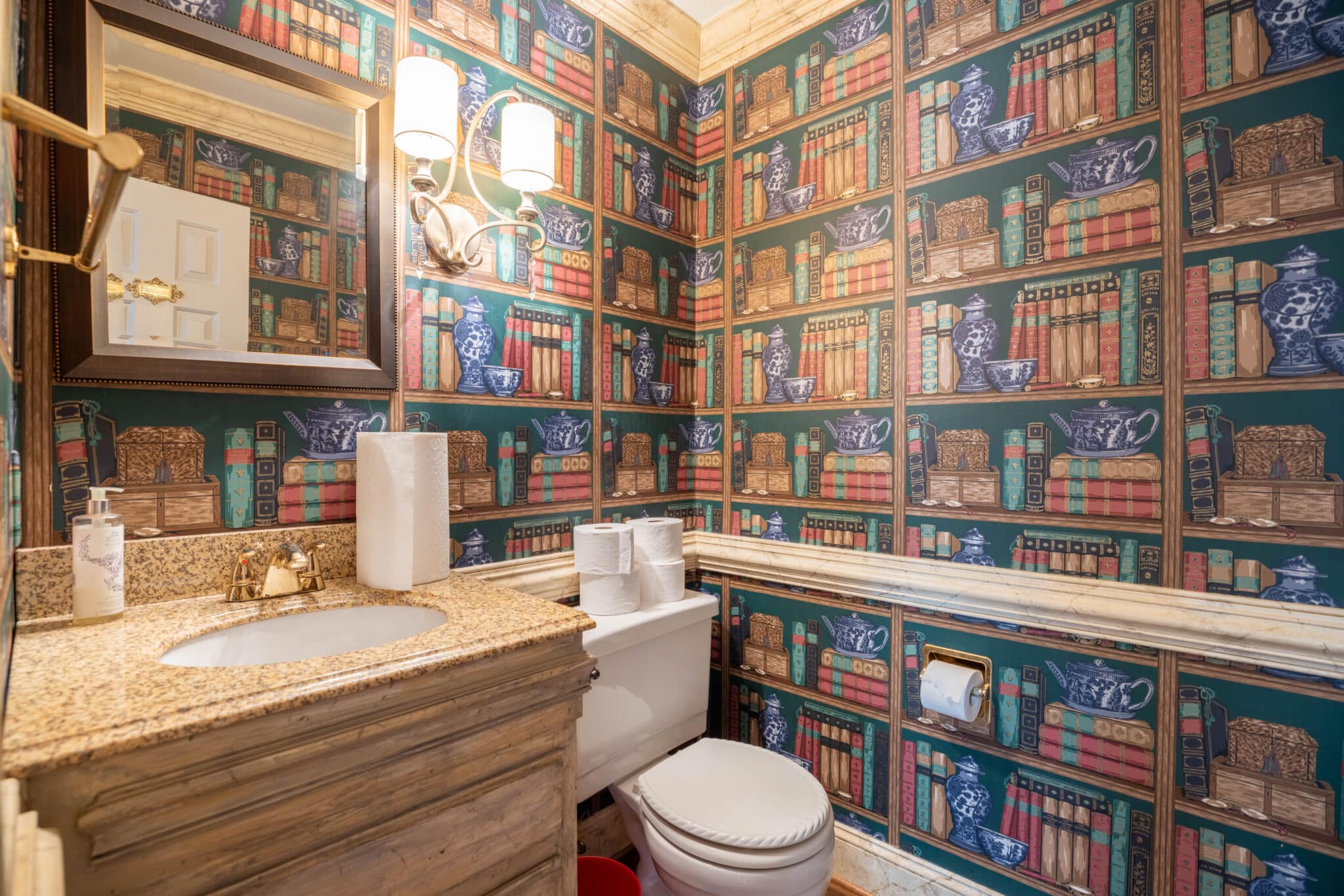 Eclectic bathroom with book-themed wallpaper.